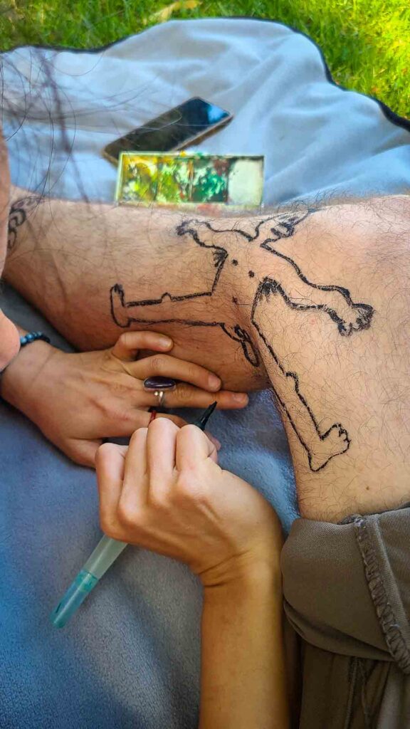 A person drawing on another person's leg