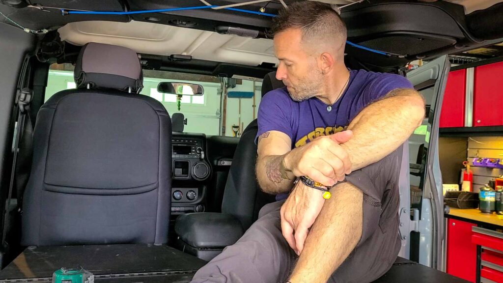 Man sitting in a Jeep wrangler on a custom bed platform