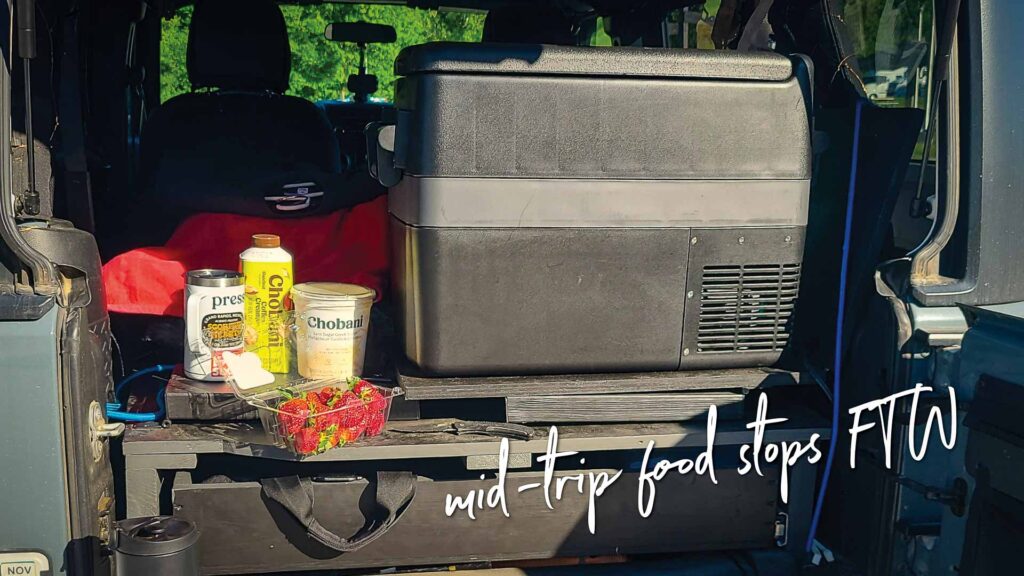 Back of a Jeep Wrangler with a sleeping platform and an RV cooler and food