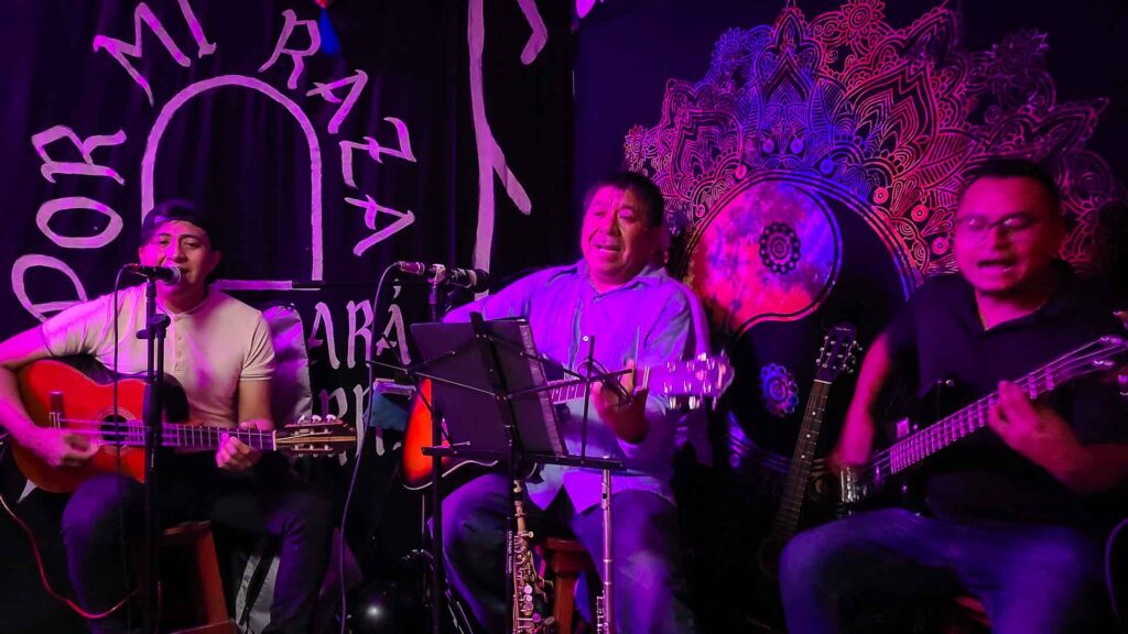 Three Mexican men playing live music in a small club